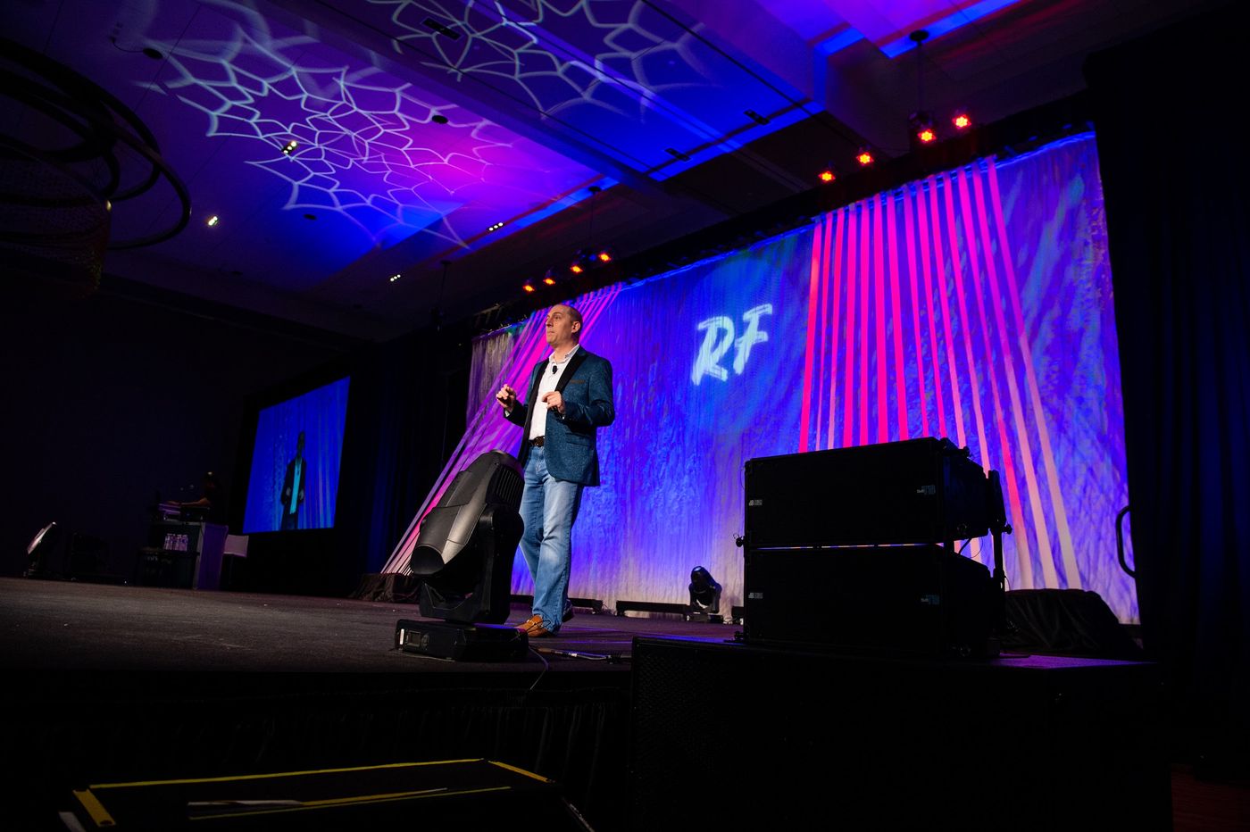 Steve Werner presenting on a large ballroom stage